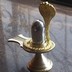 Parad Shivling weighing 200 grams having a flat base and a spherical top placed on a Brass metal yoni and a Golden colour brass metal revolvable serpant.